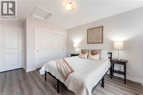 Room featuring light gray walls, wood-finish flooring, a white ceiling, and a flush-mount ceiling light - 50 Hollywood Court, Cambridge, ON - Indoor Photo Showing Bedroom
