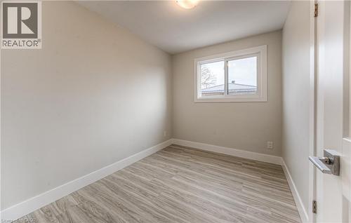 Neutral tone walls with white trim and wood-finish flooring - 40 Daniel Avenue Unit# 2, Kitchener, ON - Indoor Photo Showing Other Room