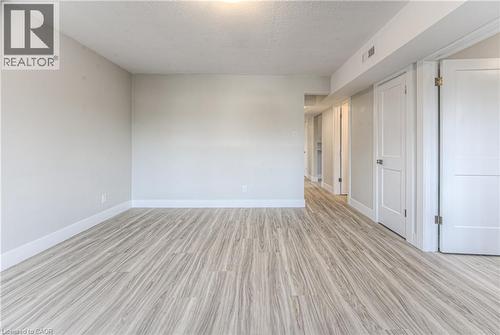 Spacious room featuring light wood-finish flooring, neutral wall paint, white baseboards, and overhead lighting - 40 Daniel Avenue Unit# 2, Kitchener, ON - Indoor Photo Showing Other Room