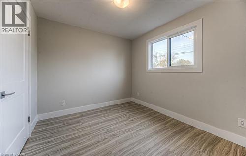Room featuring wood-finish flooring, a white trim package, and a window with white casing - 40 Daniel Avenue Unit# 2, Kitchener, ON - Indoor Photo Showing Other Room
