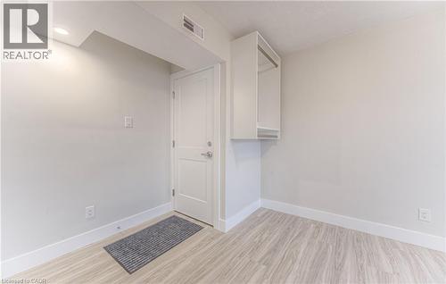 Light wood-finish flooring complements white baseboards and walls - 40 Daniel Avenue Unit# 2, Kitchener, ON - Indoor Photo Showing Other Room