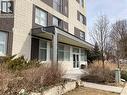 Building entrance featuring a contemporary awning, large glass doors, and surrounding low-maintenance landscaping - 392 Albert Street Unit# 302, Waterloo, ON  - Outdoor 