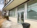 Building entrance featuring glass double doors, large storefront windows, and a protective overhead canopy with recessed lighting - 392 Albert Street Unit# 302, Waterloo, ON  - Outdoor With Exterior 