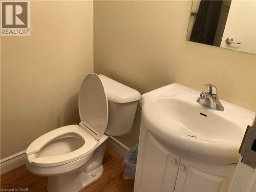 Compact bathroom featuring a white toilet, a white sink basin, and a chrome faucet - 392 Albert Street Unit# 302, Waterloo, ON - Indoor Photo Showing Bathroom