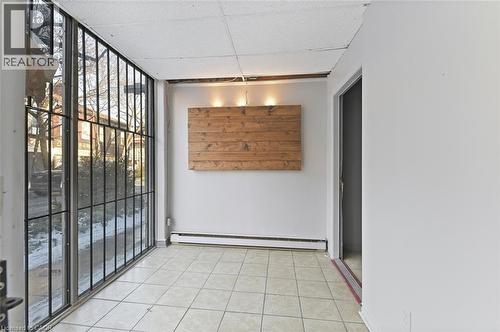 Expansive window wall with black grilles and a street-level perspective - 238-242 King Street E, Hamilton, ON 
