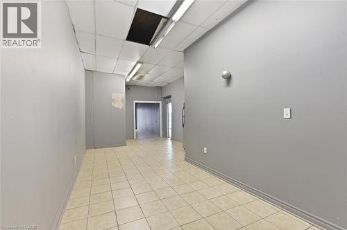 Spacious interior with neutral gray walls and light-colored square floor tiles - 238-242 King Street E, Hamilton, ON 
