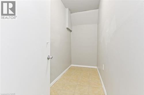 Interior storage area featuring light-toned tile flooring, light gray painted walls, and white baseboards - 238-242 King Street E, Hamilton, ON 