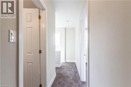 Interior hallway featuring neutral wall paint, white trim, and a textured gray carpet - 2337 Barclay Road, Burlington, ON - Indoor Photo Showing Other Room