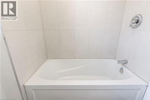 White bathtub with chrome fixtures and light-toned rectangular wall tiling - 2337 Barclay Road, Burlington, ON - Indoor Photo Showing Bathroom