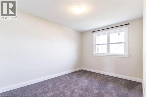 Room featuring neutral wall tones, gray carpeting, a double-hung window with white trim, a black curtain rod, and a ceiling-mounted light fixture - 2337 Barclay Road, Burlington, ON - Indoor Photo Showing Other Room