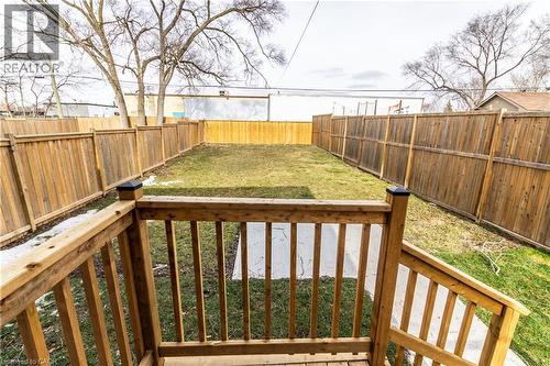 Rear yard featuring a manicured lawn, complete wood privacy fencing, and a concrete pathway - 2337 Barclay Road, Burlington, ON - Outdoor