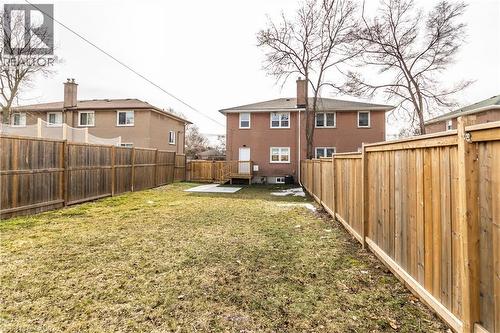 Expansive backyard featuring a partial wood privacy fence, a concrete patio area, and an exterior wood deck with stairs - 2337 Barclay Road, Burlington, ON - Outdoor With Exterior