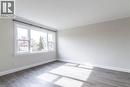 Spacious room featuring a large multi-pane window, wood-finish flooring, neutral wall tones, white trim, and crown molding - 2337 Barclay Road, Burlington, ON  - Indoor Photo Showing Other Room 