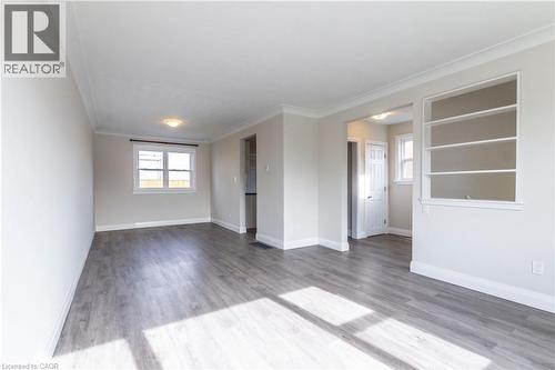 Open-concept living area featuring wood-finish flooring, recessed lighting, crown molding, built-in shelving, and white trim - 2337 Barclay Road, Burlington, ON - Indoor Photo Showing Other Room