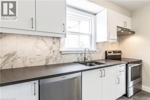 Contemporary kitchen featuring white cabinetry, dark countertops, and a full suite of stainless steel appliances - 2337 Barclay Road, Burlington, ON - Indoor Photo Showing Kitchen With Stainless Steel Kitchen With Double Sink