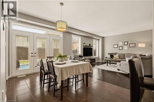 Open-concept living space featuring contrasting tile and wood-finish flooring - 42 Yager Drive, Binbrook, ON - Indoor Photo Showing Dining Room