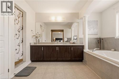 Spacious bathroom featuring a dual vanity with dark wood-finish cabinetry, light-toned countertop, and an expansive mirror - 42 Yager Drive, Binbrook, ON - Indoor Photo Showing Bathroom