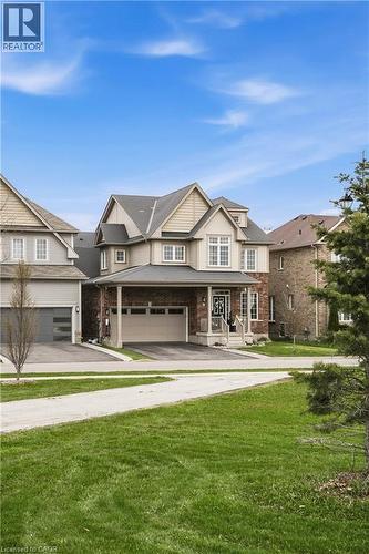 Two-story residence featuring a combination of brick and siding, a covered porch entrance, and an attached two-car garage - 42 Yager Drive, Binbrook, ON - Outdoor With Facade