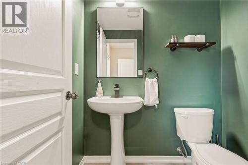 Pedestal sink with a matte black faucet, wall-mounted mirror, and decorative shelving - 42 Yager Drive, Binbrook, ON - Indoor Photo Showing Bathroom