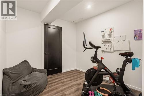 Room featuring wood-finish flooring, a dark-paneled door, and recessed lighting - 42 Yager Drive, Binbrook, ON - Indoor Photo Showing Gym Room