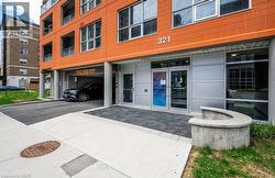 Modern building exterior featuring a vibrant orange facade and prominent street numbering - 