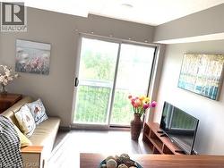 Sliding glass doors opening to a balcony, light wood-finish flooring, recessed ceiling lighting, and neutral wall tones - 