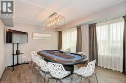 Dedicated entertainment room featuring wood-finish flooring, recessed lighting, and a contemporary linear chandelier - 