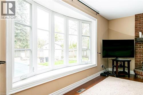 Expansive bay window with white trim, offering views of the rear yard and a covered pool area - 1577 Old Spar Court, Mississauga, ON - Indoor Photo Showing Other Room