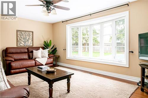 Living area featuring a prominent bay window with white trim, wood-finish flooring, and a ceiling fan with integrated lighting - 1577 Old Spar Court, Mississauga, ON - Indoor Photo Showing Living Room