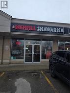 Commercial storefront featuring a prominent lighted sign, large glass display windows, and a double-door entrance - 