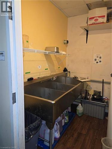 Commercial-grade three-compartment stainless steel sink with wall-mounted faucet and industrial shelving - 100 Mearns Avenue Unit# 5, Clarington, ON 