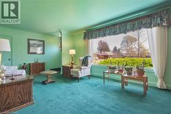 Green-hued walls and carpeting complement a large picture window - 
