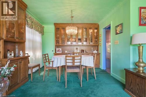 Dining space featuring a built-in wooden hutch with glass-front cabinetry, a coordinating built-in buffet, and a crystal chandelier - 2117 Edinburgh Drive, Burlington, ON - Indoor