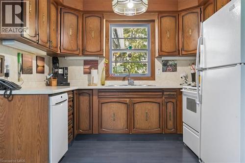 U-shaped kitchen with wood-finish cabinetry, white countertops, and a tile backsplash - 2117 Edinburgh Drive, Burlington, ON - Indoor Photo Showing Kitchen
