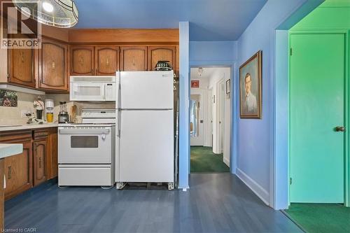 Kitchen featuring wood cabinetry, white appliances, and blue wood-finish flooring - 2117 Edinburgh Drive, Burlington, ON - Indoor Photo Showing Kitchen