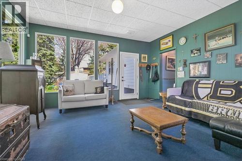 Room featuring wood-paneled walls, blue carpeting, and a white grid ceiling - 2117 Edinburgh Drive, Burlington, ON - Indoor Photo Showing Living Room