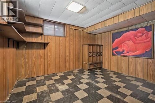 Versatile room featuring wood-finish paneling, a drop ceiling, and a checkerboard floor pattern - 2117 Edinburgh Drive, Burlington, ON - Indoor