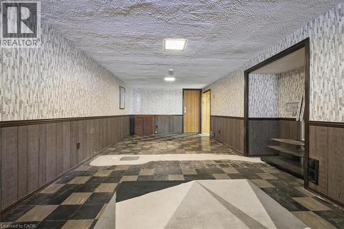 Spacious room featuring patterned wallpaper, wood-panel wainscoting, and a checkered floor - 2117 Edinburgh Drive, Burlington, ON -  Photo Showing Other Room