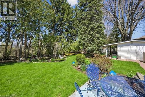 Expansive backyard featuring a manicured lawn, established trees, and a dedicated patio area - 2117 Edinburgh Drive, Burlington, ON - Outdoor