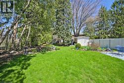 Expansive green lawn with established trees and shrubs - 