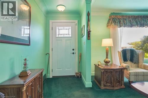 Entryway featuring a white door with a leaded glass transom window, green wall paint, green carpet flooring, and a flush-mount ceiling light - 2117 Edinburgh Drive, Burlington, ON - Indoor Photo Showing Other Room