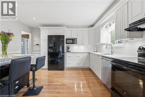 White eat-in kitchen with quartz and view to private backyard - 668 Tomahawk Crescent, Ancaster, ON - Indoor Photo Showing Kitchen With Upgraded Kitchen