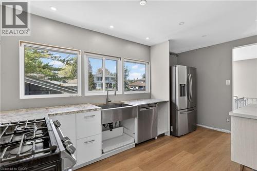 Kitchen featuring stainless steel appliances, a farmhouse sink, stone countertops, and recessed lighting - 515 Bobbybrook Drive, London, ON - Indoor Photo Showing Kitchen