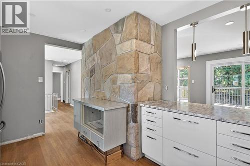 Stone accent wall with a wood-finish floor - 515 Bobbybrook Drive, London, ON - Indoor Photo Showing Kitchen With Upgraded Kitchen