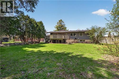 Expansive backyard featuring a manicured lawn, mature trees, and a wooden deck with railing - 515 Bobbybrook Drive, London, ON - Outdoor