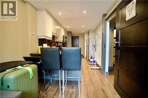Kitchenette featuring light-toned upper cabinetry, dark countertops, and stainless steel appliances - 330 Phillip Street Unit# S605, Waterloo, ON - Indoor