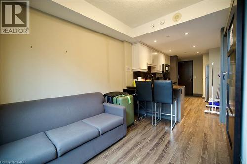 Open-concept living space with wood-finish flooring, a contemporary kitchen, recessed lighting, and a kitchen island with seating - 330 Phillip Street Unit# S605, Waterloo, ON - Indoor