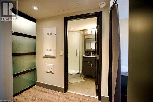 Contemporary bathroom featuring a dark wood-finish vanity with a dark countertop, a framed mirror, and a glass-enclosed shower - 330 Phillip Street Unit# S605, Waterloo, ON - Indoor