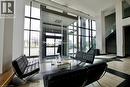 Contemporary lobby featuring expansive window walls, light-toned tile flooring with dark accents, a prominent staircase with glass railings, and a glass-enclosed entrance - 330 Phillip Street Unit# S605, Waterloo, ON  - Indoor 