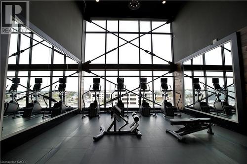 Fitness center featuring high ceilings, expansive window walls with structural cross beams, and durable rubber flooring - 330 Phillip Street Unit# S605, Waterloo, ON - Indoor Photo Showing Gym Room